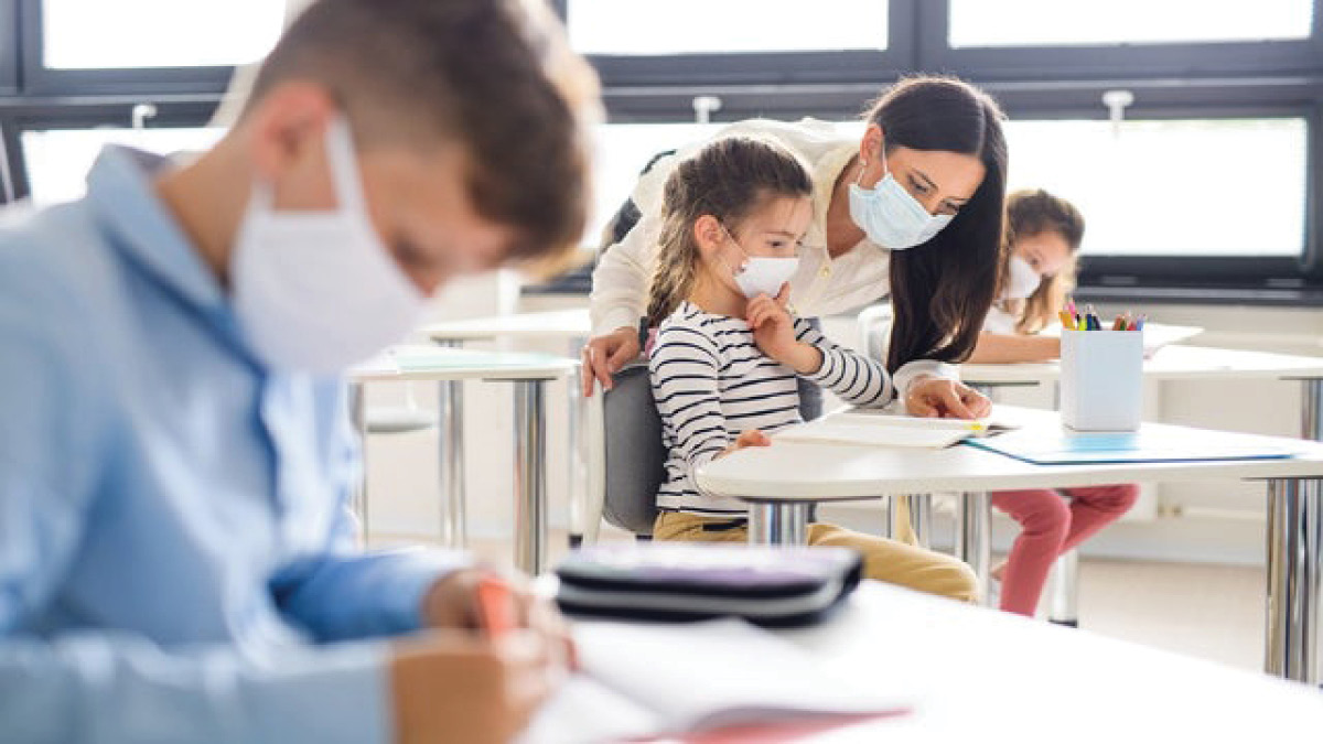 Kids wearing masks in classroom while at school
