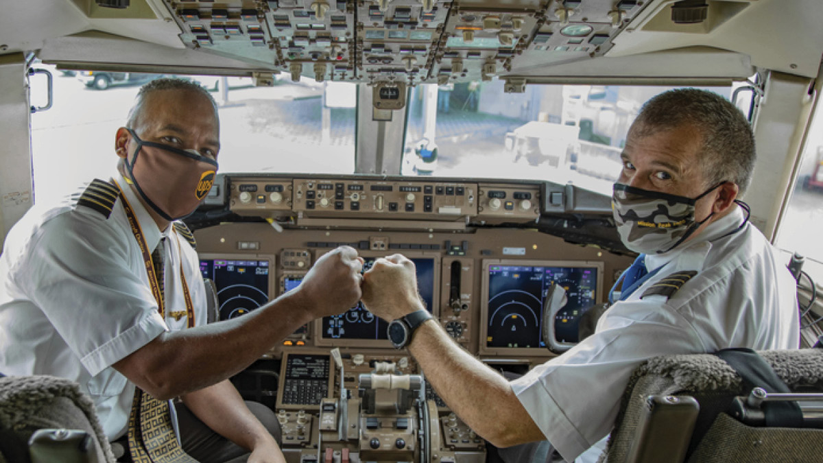 Two pilots fist pumping in cockpit
